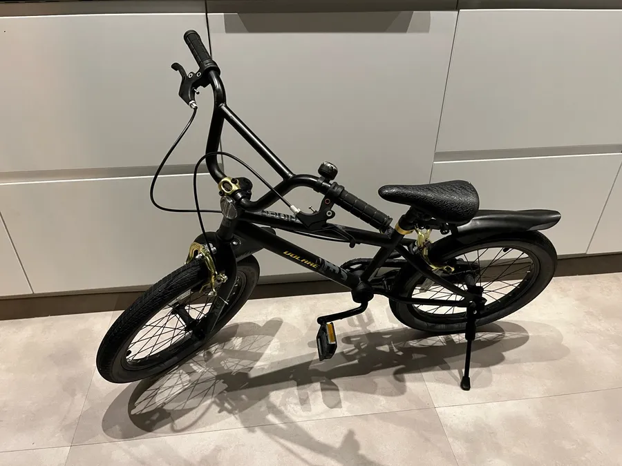 Black 18-inch kids bike standing on its own with the Kickaroo kickstand deployed, photographed by a verified buyer