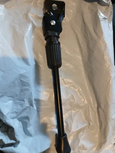 Kickstand unpacked on its wrapping, showing the mounting plate, the collar and the rubber foot, photographed by a verified buyer